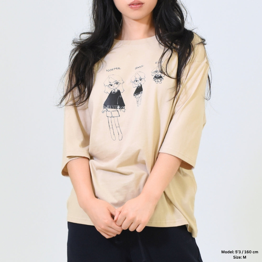 Person wearing a beige oversized t-shirt with graphic design on a plain background