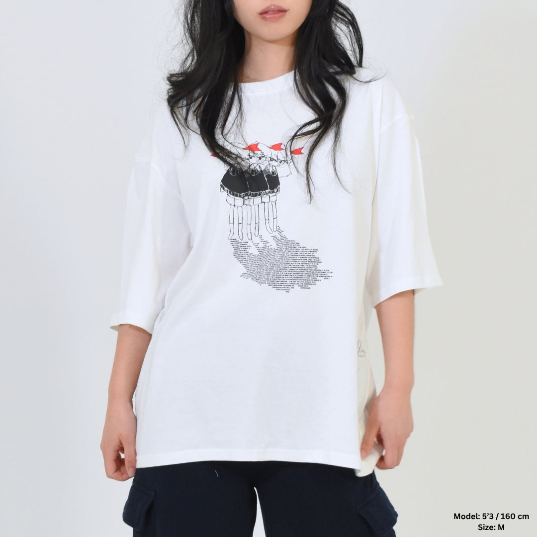 Person wearing a white t-shirt with a graphic design on a plain background
