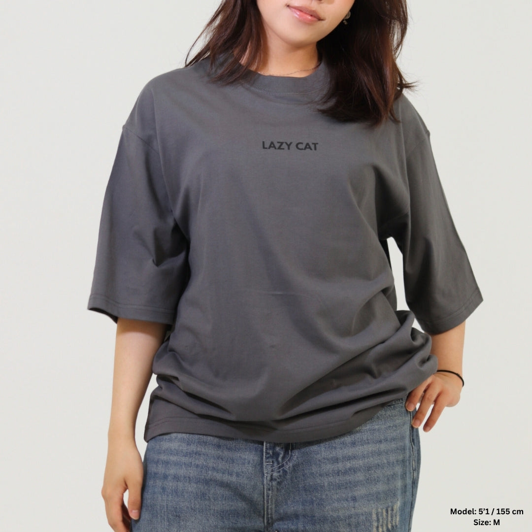 Person wearing a gray t-shirt with 'LAZY CAT' text on a plain background