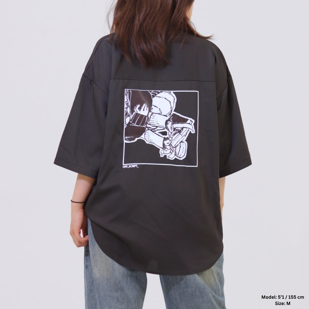 Person wearing a black oversized shirt with a graphic design on the back against a plain background