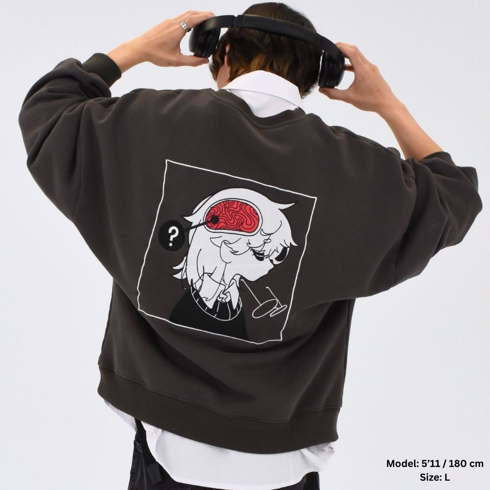 A person wearing a dark green fully embroidered sweater with a graphic design on the back, over a white shirt.