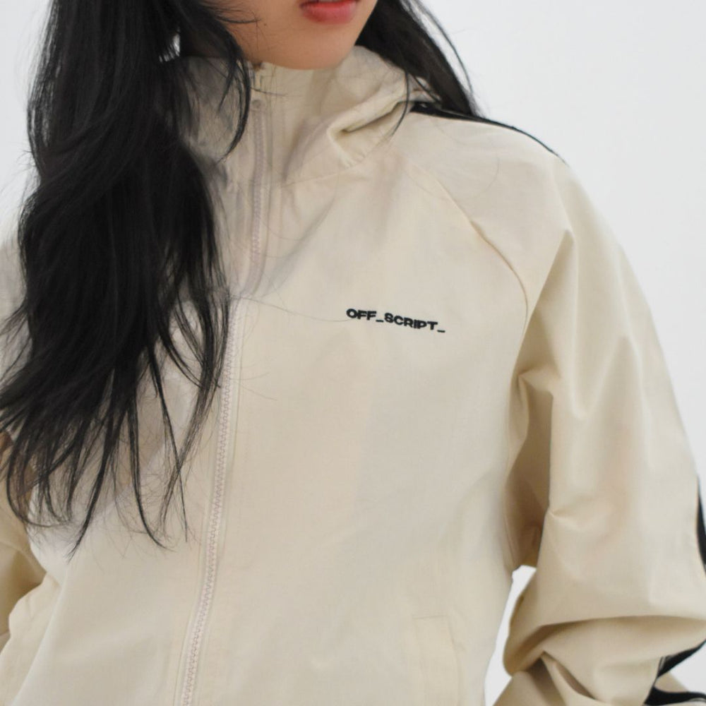 Person wearing a beige jacket with 'OFF SCRIPT' branding on a white background