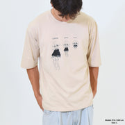 Person wearing a beige t-shirt with cartoon character design on a plain background