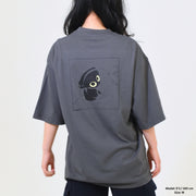 Person wearing a gray t-shirt with a graphic design on the back against a plain background
