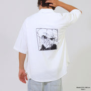 Person wearing a white shirt with a graphic design on the back against a plain background