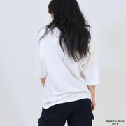 Person wearing a white shirt and dark pants against a plain background