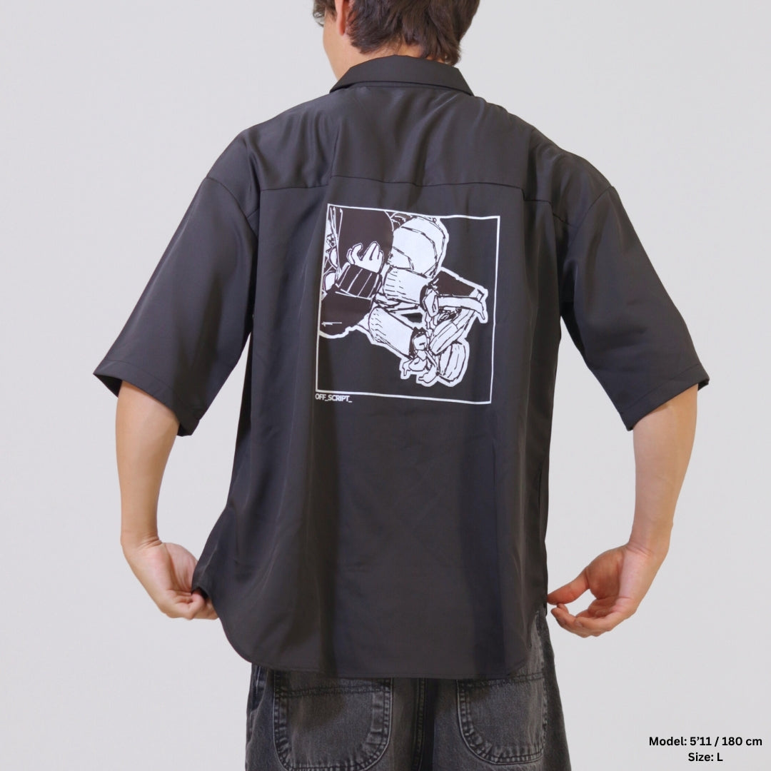 Person wearing a black shirt with a graphic design on the back against a plain background