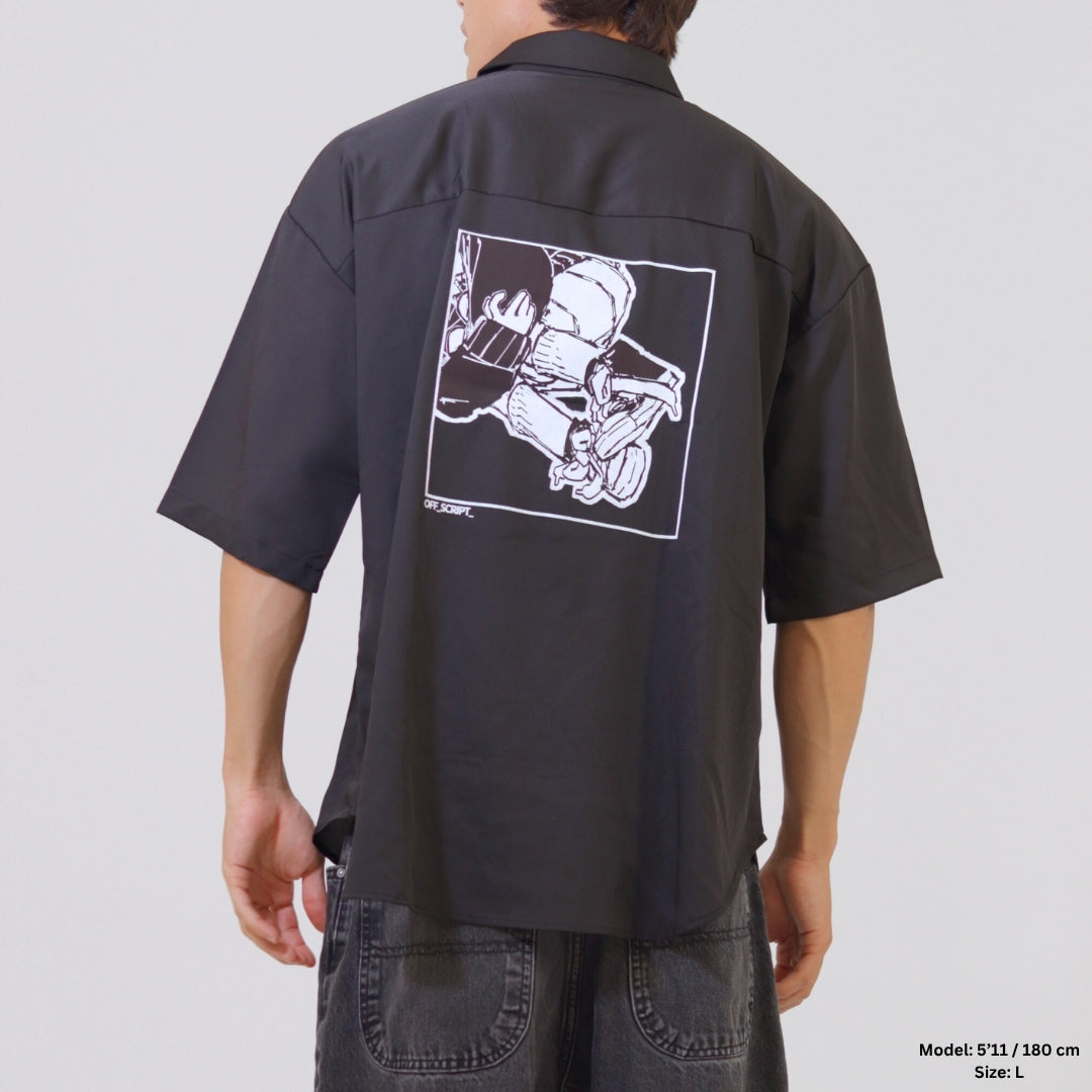 Person wearing a black short-sleeve shirt with a graphic on the back against a plain background