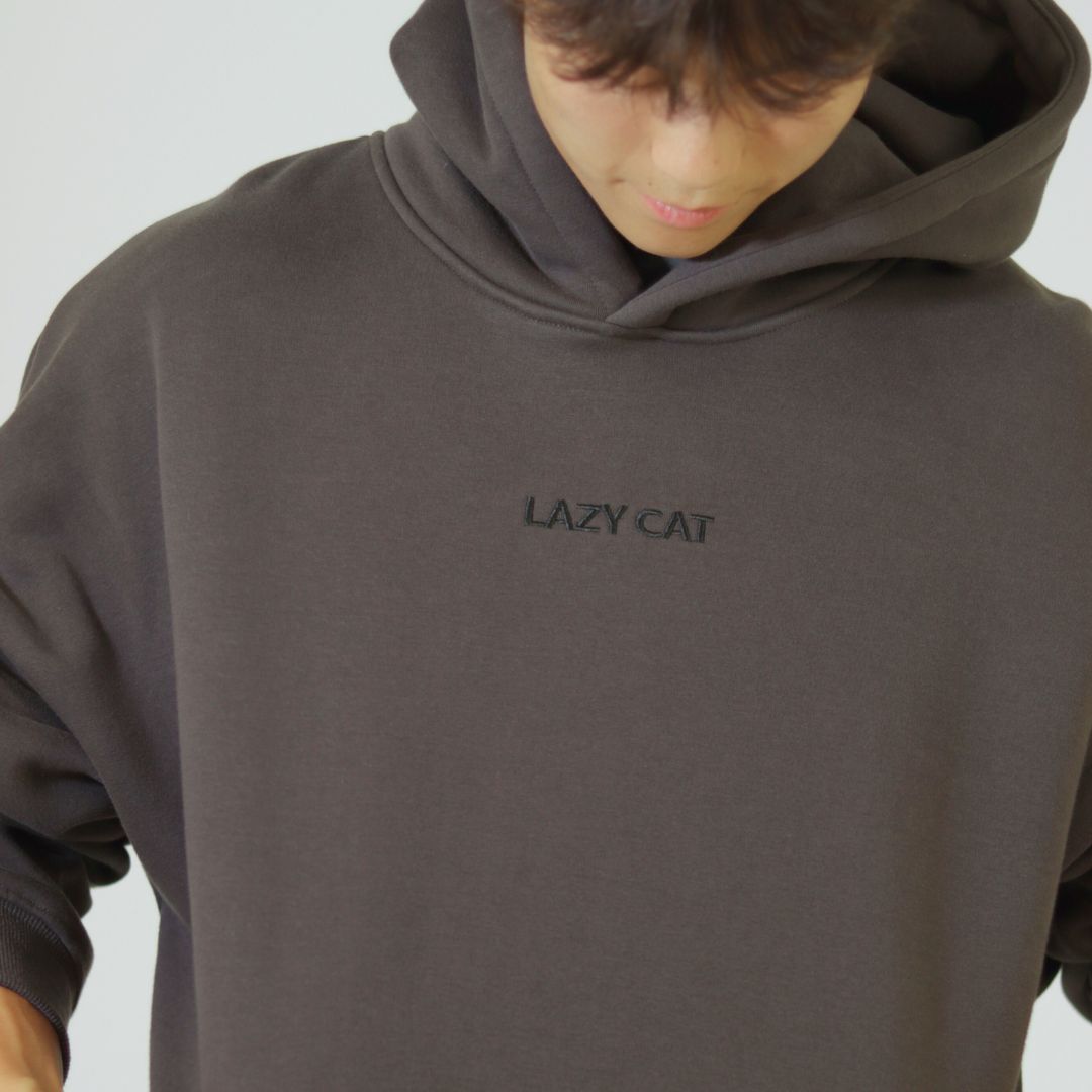 Person wearing a brown hoodie with 'LAZY CAT' text on a gray background