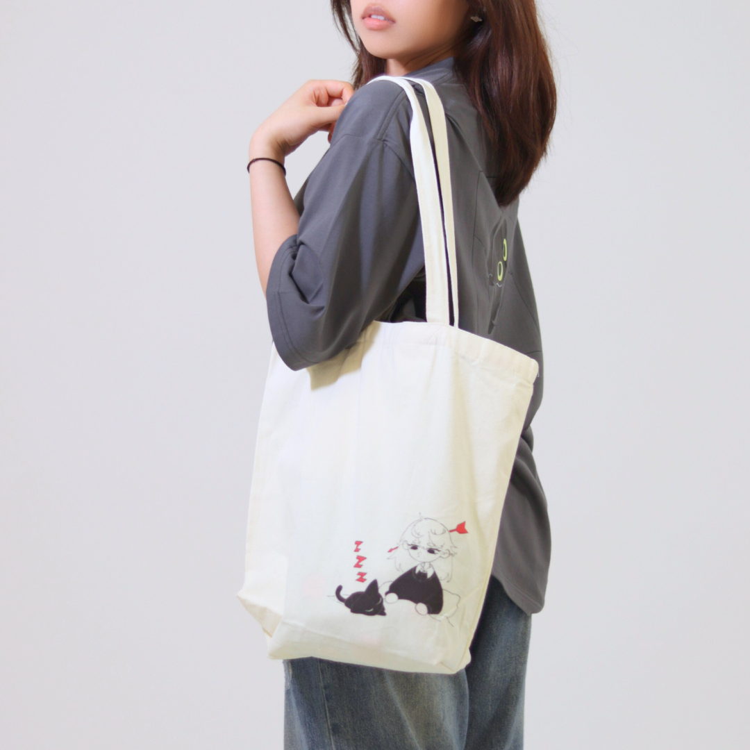 Person wearing a tote bag with a design of a dog and a heart on a plain background