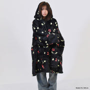 Person wearing a black hoodie with colorful cat patterns on a white background