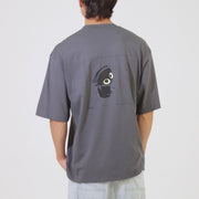 Person wearing a gray t-shirt with a graphic design on the back against a plain background